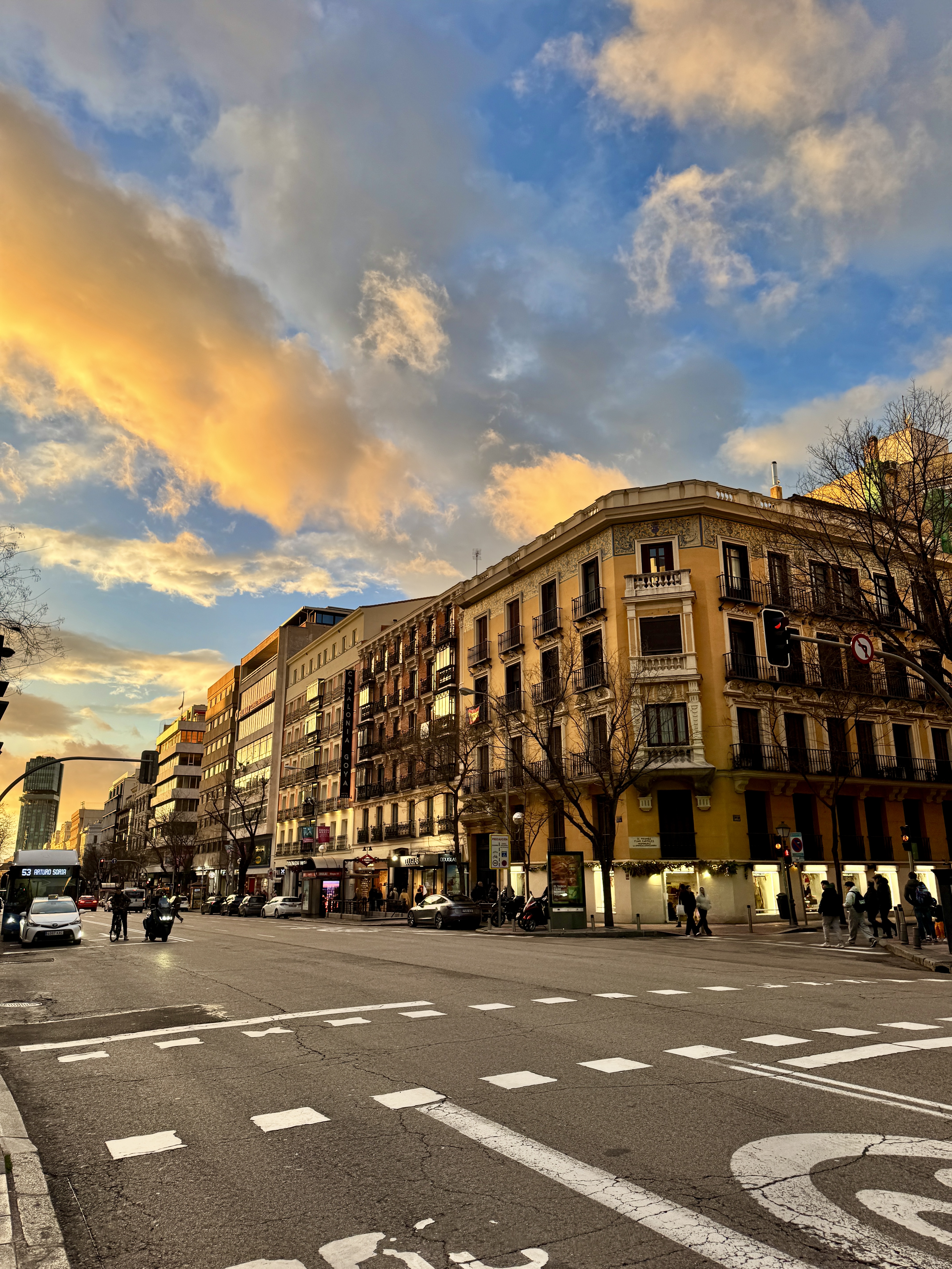 Sunset over the rooftops with television antennas silhouetted against orange sky.
